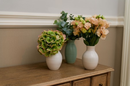 Centro de mesa con jarrones blancos y verdes con flor variada